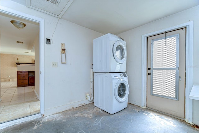 laundry room featuring laundry area, stacked washer and dryer, and visible vents