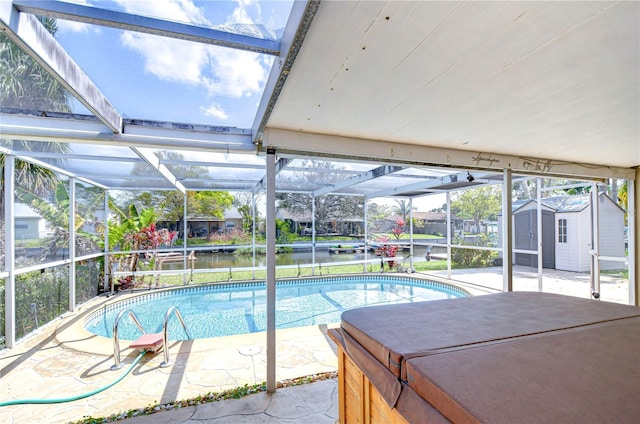 outdoor pool with a patio, glass enclosure, a storage shed, an outdoor structure, and a hot tub