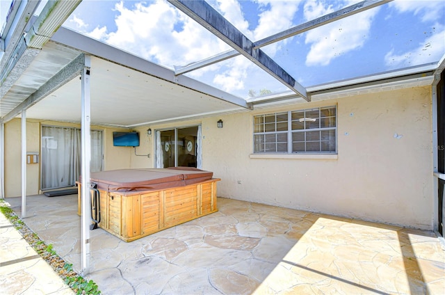 view of patio featuring a lanai and a hot tub