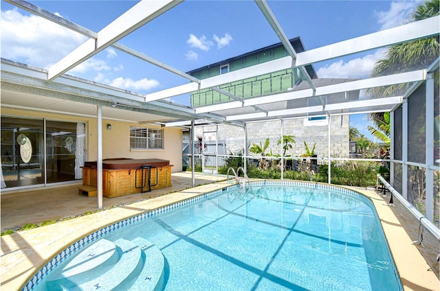 pool featuring a hot tub, a lanai, and a patio area