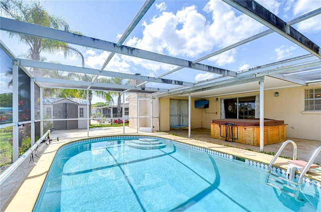 pool with a patio area, a shed, glass enclosure, and a hot tub