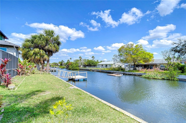 view of dock with a yard and a water view