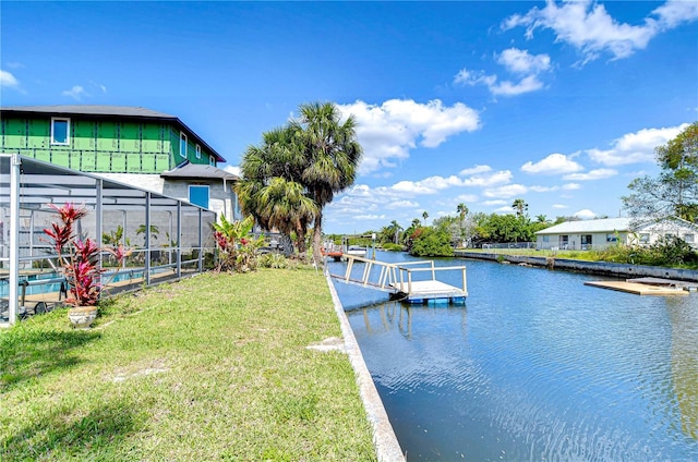 view of dock with glass enclosure, a water view, and a lawn