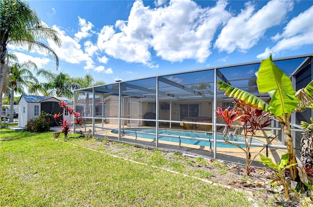 pool featuring a storage unit, a yard, an outbuilding, and a lanai