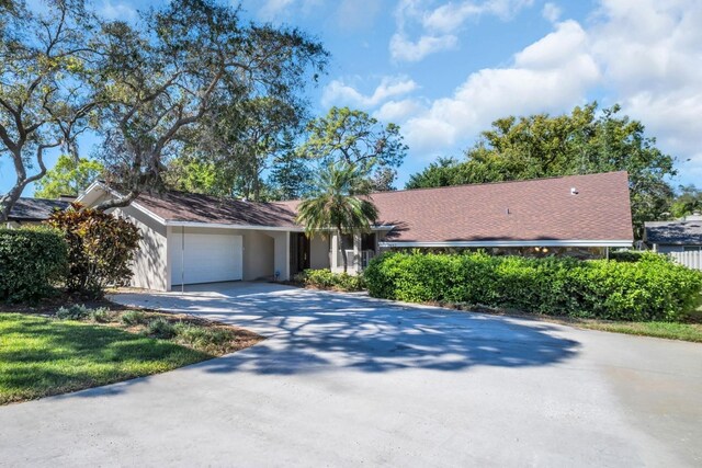 2462 Indian Trl E, Palm Harbor, FL 34683 - ranch-style house featuring an attached garage and driveway