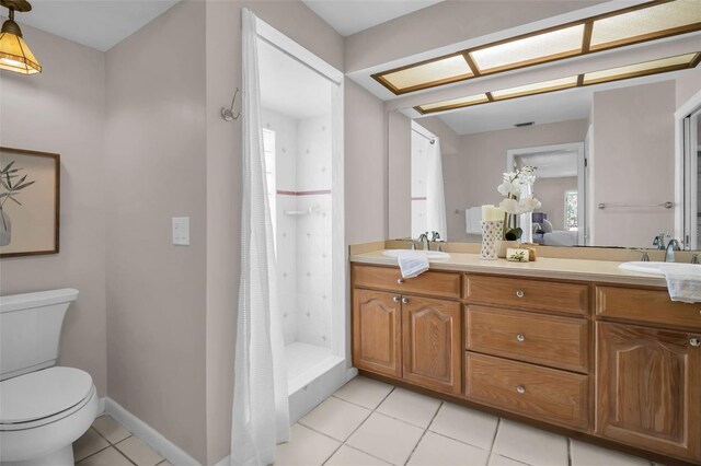 2462 Indian Trl E, Palm Harbor, FL 34683 - full bath with toilet, tile patterned floors, double vanity, a stall shower, and baseboards