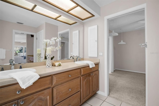 2462 Indian Trl E, Palm Harbor, FL 34683 - bathroom featuring double vanity, connected bathroom, tile patterned flooring, and baseboards