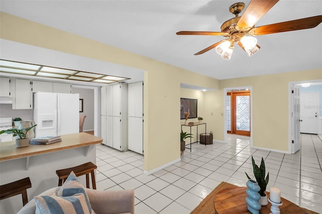 2462 Indian Trl E, Palm Harbor, FL 34683 - living area with light tile patterned floors, baseboards, and a ceiling fan