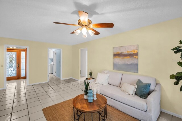 2462 Indian Trl E, Palm Harbor, FL 34683 - living area featuring light tile patterned floors, baseboards, ceiling fan, and washer / clothes dryer