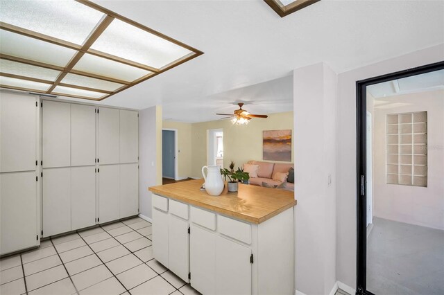 2462 Indian Trl E, Palm Harbor, FL 34683 - kitchen with light countertops, ceiling fan, white cabinets, light tile patterned floors, and a peninsula