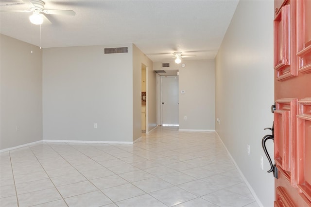 spare room with light tile patterned flooring, visible vents, baseboards, and ceiling fan