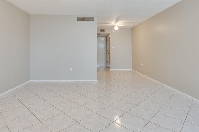 empty room with baseboards, visible vents, and ceiling fan