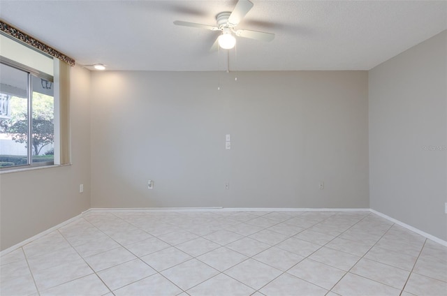 spare room with a textured ceiling, baseboards, and ceiling fan