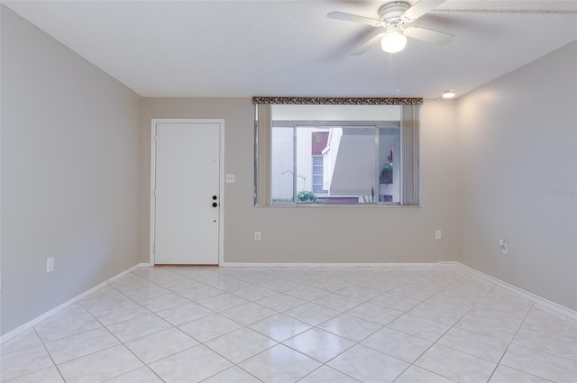 spare room featuring a ceiling fan and baseboards