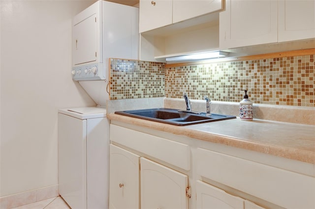 kitchen with a sink, tasteful backsplash, light countertops, and white cabinetry