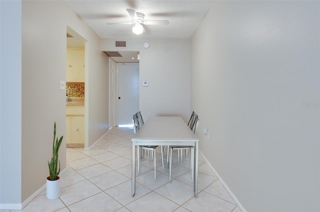 dining room with a textured ceiling, light tile patterned flooring, visible vents, and ceiling fan