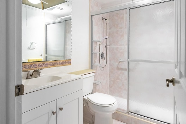 bathroom with visible vents, toilet, a stall shower, and vanity