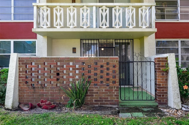 property entrance featuring a balcony and stucco siding