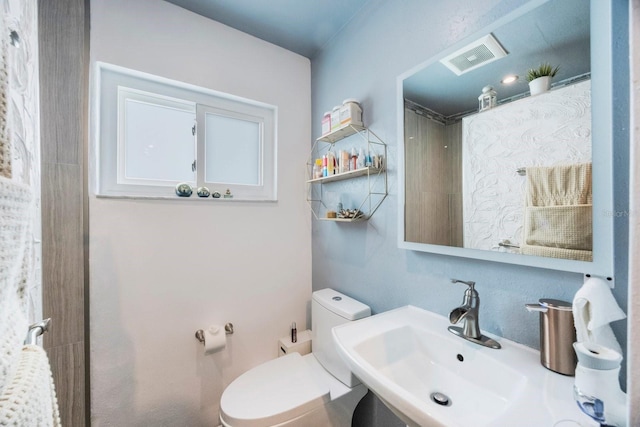 bathroom with a sink, visible vents, and toilet