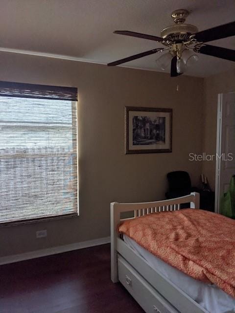 bedroom featuring baseboards, dark wood-type flooring, and a ceiling fan