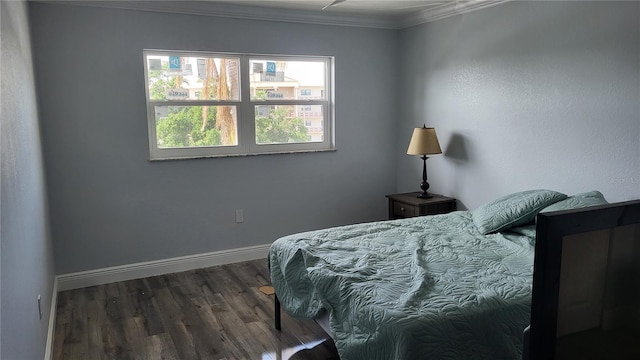 bedroom with baseboards, ornamental molding, and wood finished floors