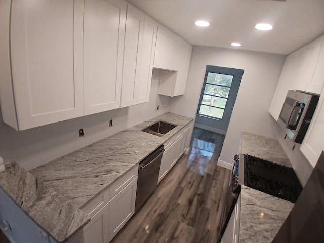 kitchen featuring white cabinets, baseboards, light stone countertops, dark wood-type flooring, and stainless steel appliances