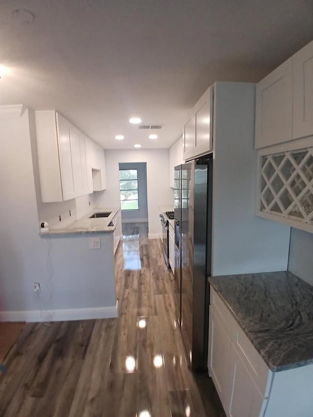 kitchen with visible vents, white cabinets, appliances with stainless steel finishes, baseboards, and dark wood-style floors
