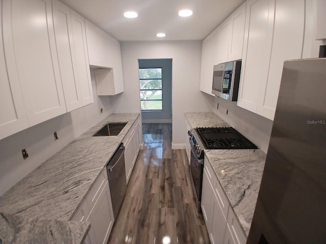 kitchen with a sink, dark wood finished floors, white cabinets, and stainless steel appliances