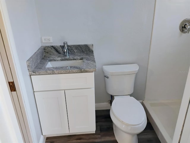 full bathroom with a shower stall, vanity, toilet, wood finished floors, and baseboards