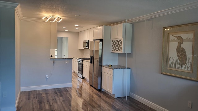 kitchen with dark wood finished floors, appliances with stainless steel finishes, baseboards, and white cabinetry