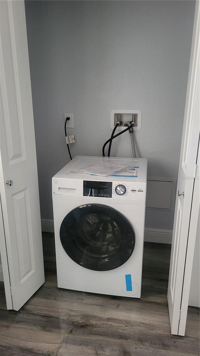 laundry room featuring washer / clothes dryer, baseboards, laundry area, and dark wood-style floors