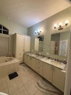 full bathroom with tile patterned flooring, double vanity, a garden tub, and a sink