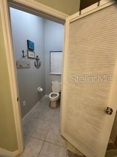 bathroom featuring tile patterned floors, toilet, and baseboards