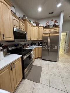 kitchen featuring light tile patterned floors, stainless steel appliances, visible vents, and light countertops