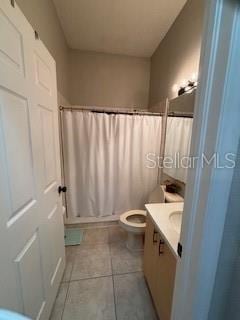 full bathroom featuring tile patterned flooring, toilet, vanity, and a shower with curtain