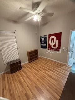 unfurnished bedroom featuring ceiling fan, baseboards, and wood finished floors