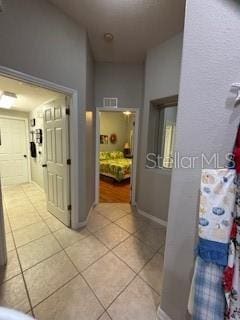 hallway featuring light tile patterned flooring and baseboards