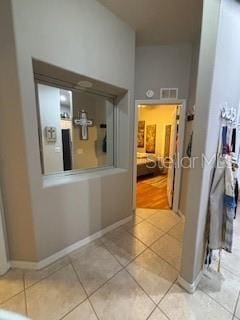 corridor with light tile patterned floors and baseboards