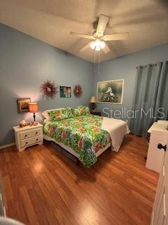 bedroom with a ceiling fan and wood finished floors