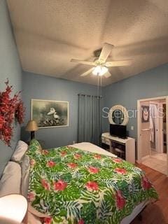 bedroom featuring a textured ceiling, lofted ceiling, wood finished floors, and ceiling fan