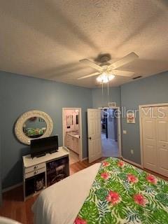 bedroom featuring a textured ceiling, a ceiling fan, and wood finished floors