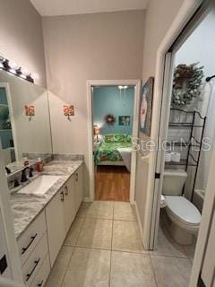 full bath featuring vanity, toilet, tile patterned flooring, and connected bathroom