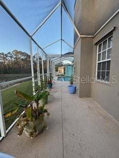 view of patio / terrace with glass enclosure and an outdoor pool