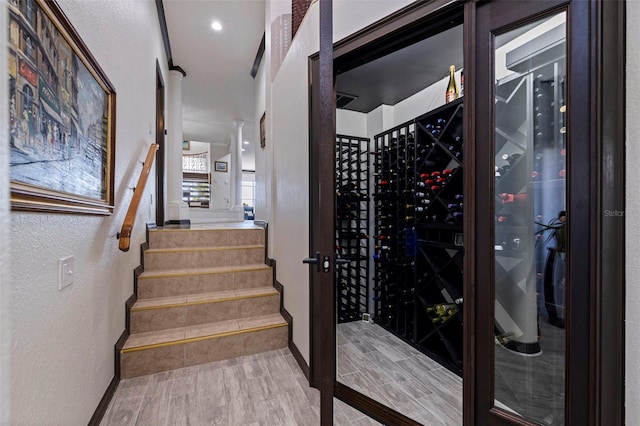 wine room featuring a textured wall, wood finished floors, and baseboards