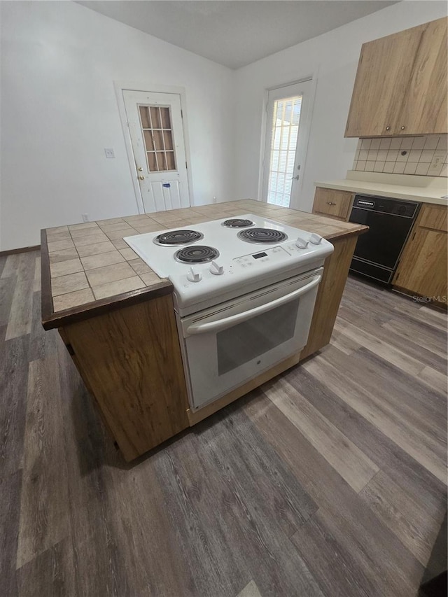kitchen with tile countertops, dark wood-style flooring, electric stove, dishwasher, and backsplash