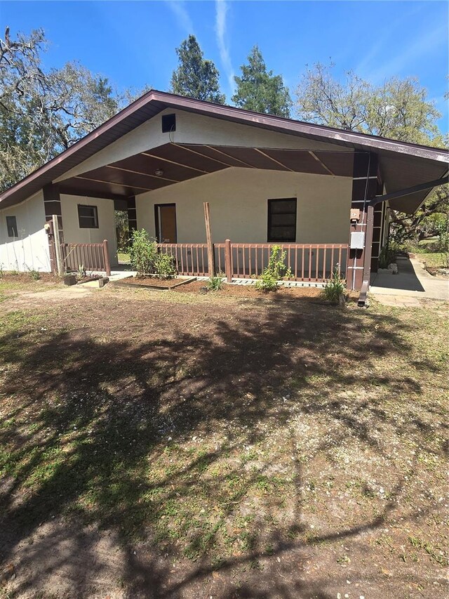 view of front of property featuring an attached carport and covered porch