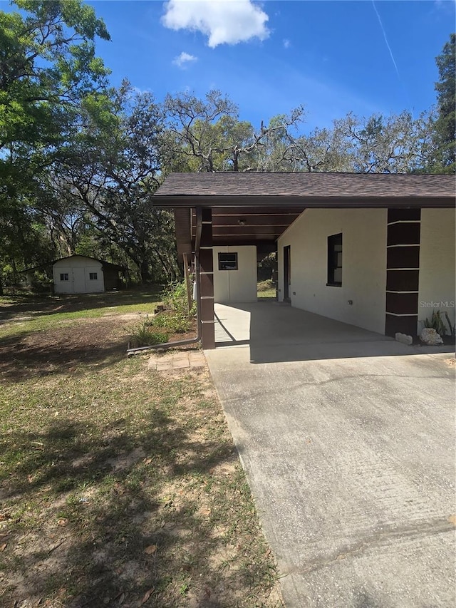 exterior space featuring a carport, stucco siding, and driveway