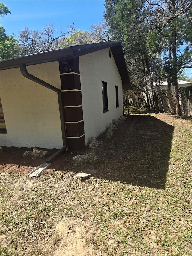 view of property exterior featuring stucco siding and fence