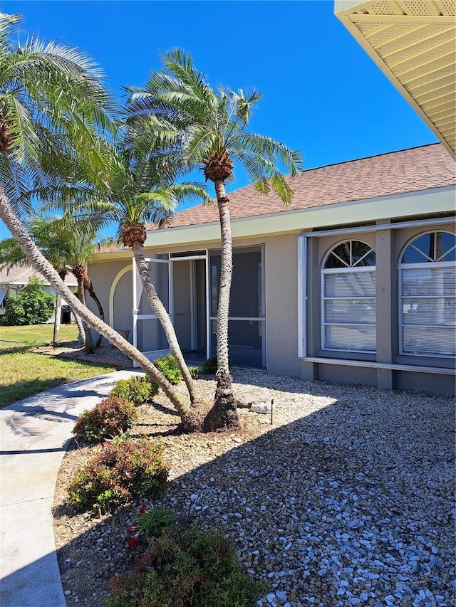 26 Clintwood Ave, Englewood, FL 34223 - ranch-style house featuring stucco siding, a shingled roof, and a sunroom