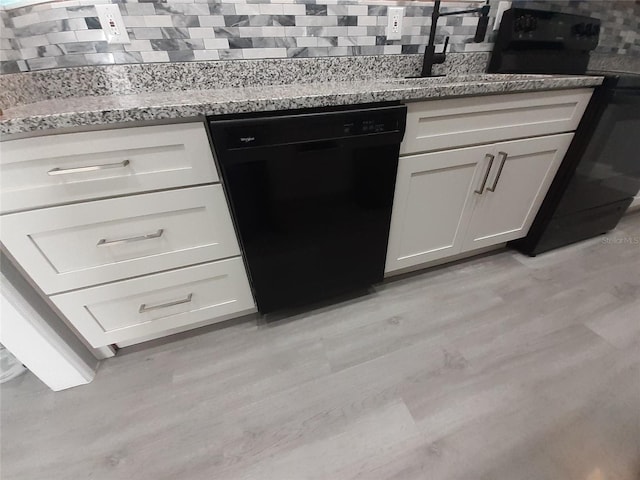 26 Clintwood Ave, Englewood, FL 34223 - kitchen with black appliances, light wood-type flooring, decorative backsplash, and light stone countertops